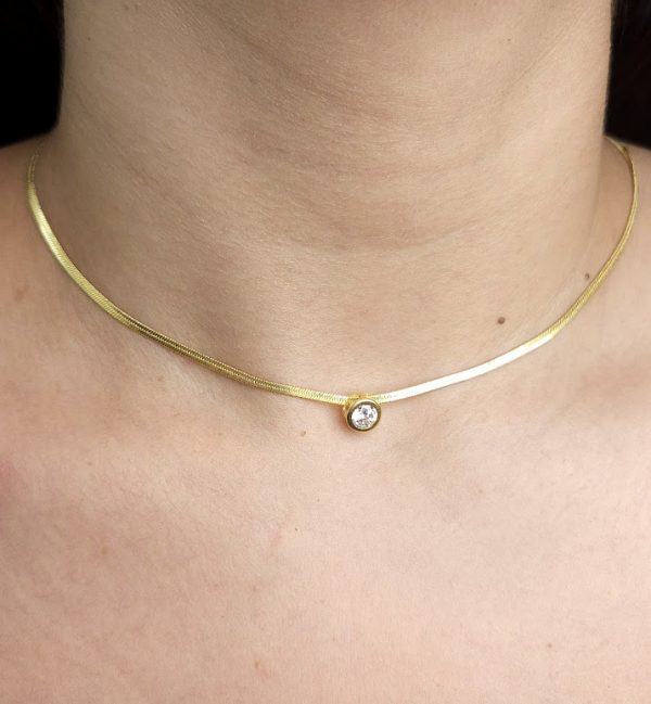 Choker malha laminada com pedra cristal e base dourada