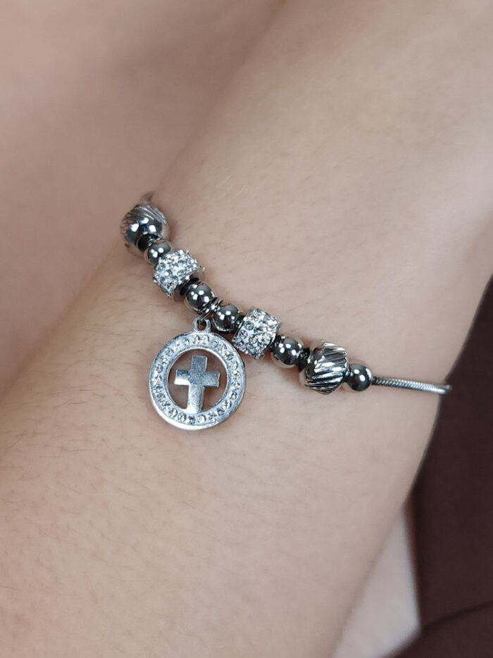 Pulseira bolas prateada e cravejada com pingente cruz detalhe vazado