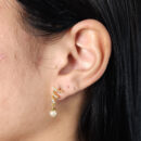 Brinco fio ondulado cravejado com pêndulo pérola