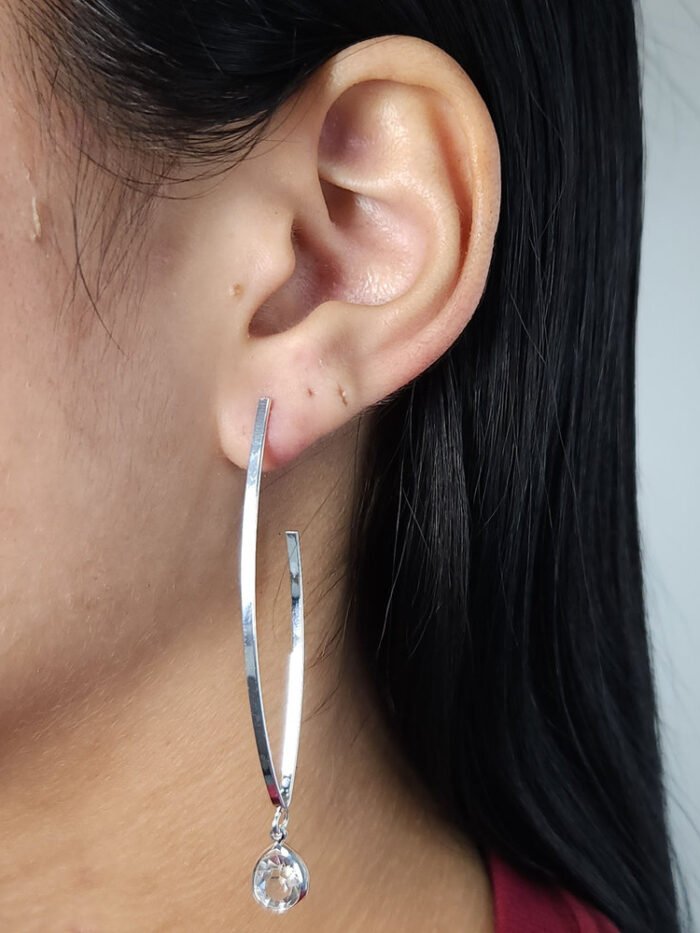 Brinco modelo oval aberto com pêndulo gota de cristal