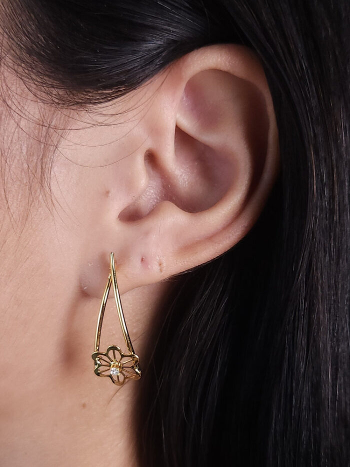 Brinco fios lisos com flor vazada e pedrinha cristal