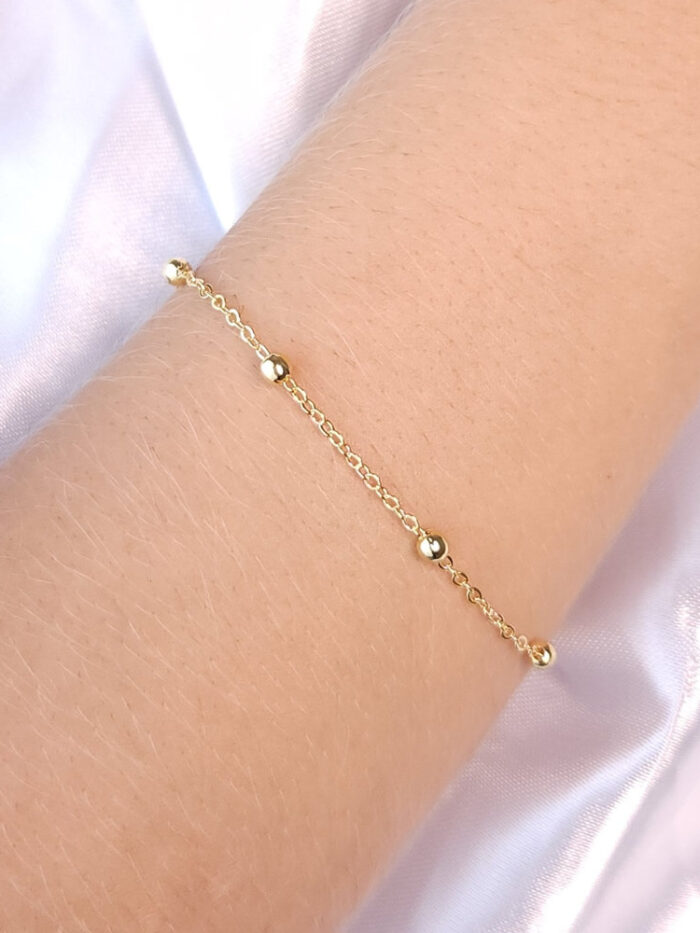 Pulseira elo americano com bolas douradas